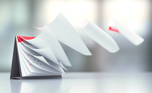 Pages Of A Red Calendar Standing Over Defocused Background Are Flying Away Pages of a red calendar standing over defocused background are flying away. Horizontal composition with copy space. Calendar and reminder concept with selective focus. annual event stock pictures, royalty-free photos & images