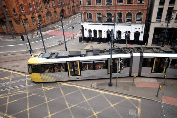 Tram in Manchester A tram passing near the Piccadilly station in Manchester Long exposure photo makes the tram passenger unrecognizable. blurred motion street car green stock pictures, royalty-free photos & images