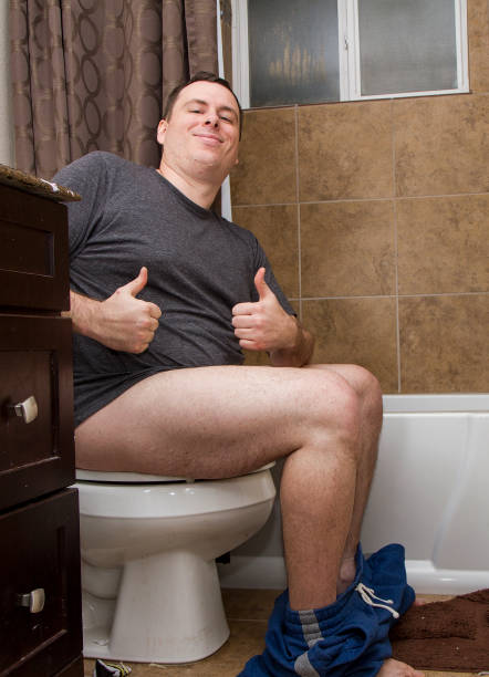 Man in a dirty bathroom giving the thumbs up