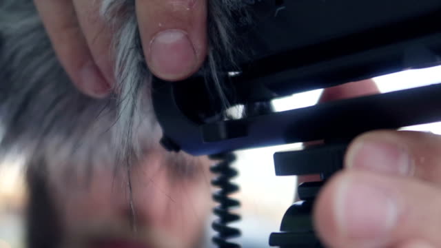 Handsome bearded man prepares vlogging microphone for IGTV - Stock video
