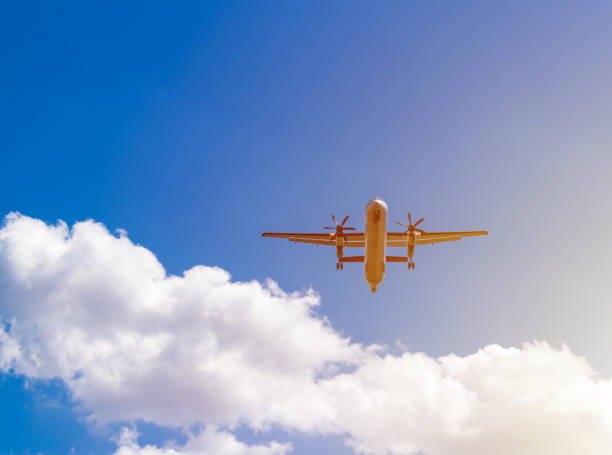 istock airplane flying against blue sky, white clouds behind 1033893034