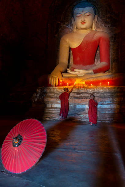 Two young buddhist monk praying inside the temple in Bagan, Myanmar