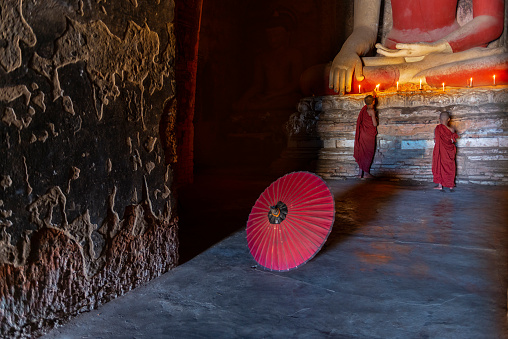 Two young buddhist monk praying inside the temple in Bagan, Myanmar