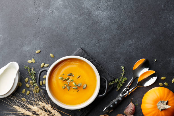 zuppa di zucca con timo e semi di zucca su sfondo nero - soup pumpkin soup vegetarian food food foto e immagini stock