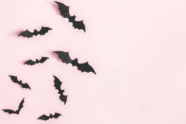 Halloween paper decorations on pastel pink background. Halloween concept. Flat lay, top view, copy space