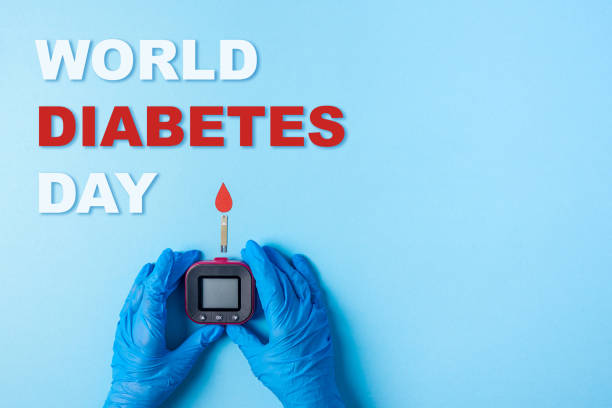 inscription world diabetes day and Nurse making a blood test with red blood drop with Blood glucose test strip and Glucose meter stock photo