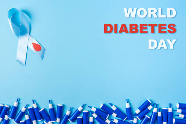 inscription world diabetes day blue ribbon awareness with red blood drop and line of lancets on a blue background, World diabetes day stock photo