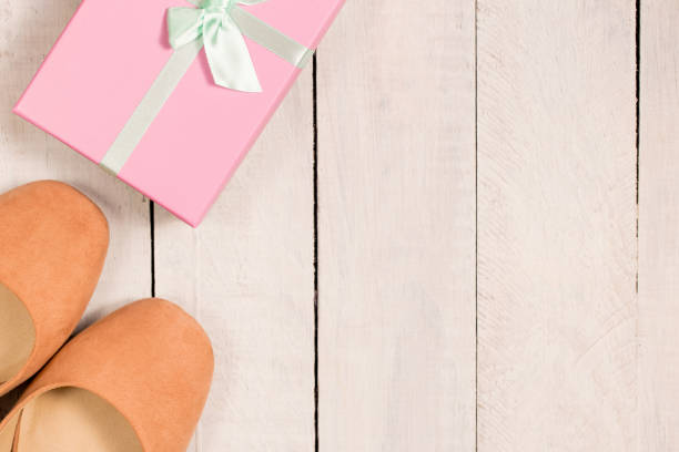 istock Two gift boxes on white desk. Flat lay. Space for text. Beige woman shoes. 1033927300