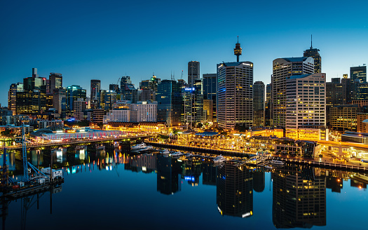 Beautiful illuminated modern Skyscraper Cityscape of Darling Harbour reflecting in the harbor. Shot from above. Darling Harbor, Sydney, New South Wales, Australia.