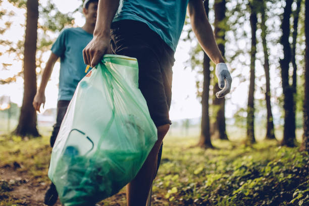 group of volunteers collecting garbage in park - bag garbage bag plastic black imagens e fotografias de stock