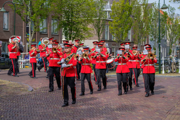 colorful musicians in beautiful uniforms march through the streets of delft, the netherlands. - parade band imagens e fotografias de stock