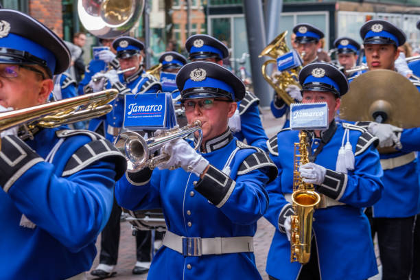 musicisti colorati in belle uniformi marciano per le strade di delft, nei paesi bassi. - marching band trumpet bugle marching foto e immagini stock