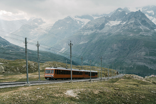 Scenic view of train on railroad in Swiss alps near Matterhorn mountain. Gornergrat train