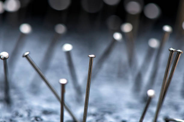 Multicolored sewing pins or push pin needles laid loose on white background
