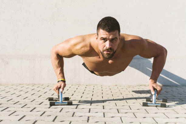 muscular build man doing push ups outdoors - exercising men push ups muscular build imagens e fotografias de stock