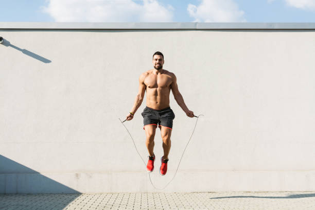 Young muscular man skipping rope outdoors stock photo