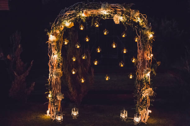 夜の結婚式、パーティー ライトや丸いガラス球のキャンドルで飾られたアーチ - deciduous tree flash ストックフォトと画像