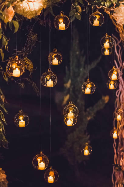 夜の結婚式、パーティー ライトや丸いガラス球のキャンドルで飾られたアーチ - deciduous tree flash ストックフォトと画像