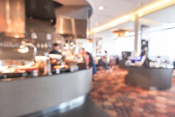 istock Buffet at hotel restaurant interior blur background with blurry open kitchen counter bar of food catering service business with chef staff cooking for breakfast, lunch or dinner meal 1034035506