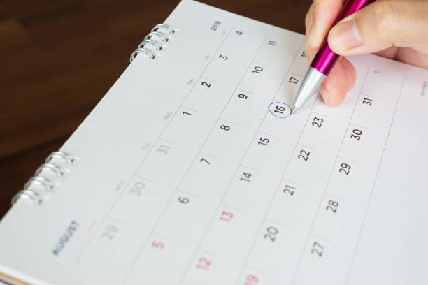 istock female hand holding pen circle mark on calendar page 1034036064