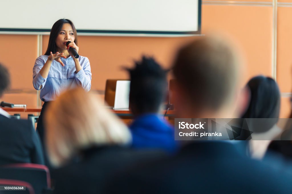 Business presentation An Asian female presenter interacting with the audience at a business presentation in the board room Public Speaker Stock Photo