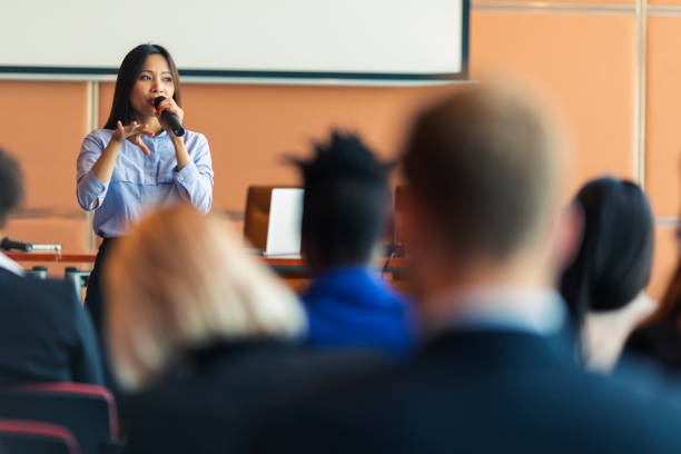 Business presentation An Asian female presenter interacting with the audience at a business presentation in the board room slovenia photos stock pictures, royalty-free photos & images