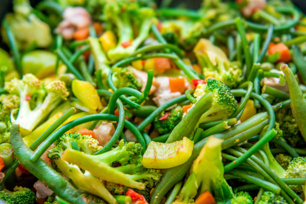 fresh roasted vegetables. pepper, garlic broccoli, arrows and lots of peas. a beautiful mix of vegetables.