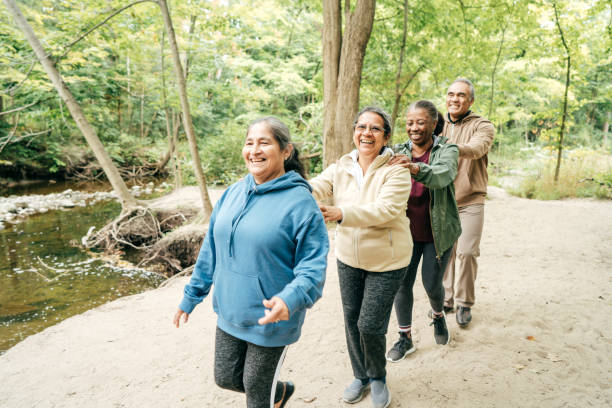 group of seniors  exercising in the park - walking exercising relaxation exercise group of people imagens e fotografias de stock