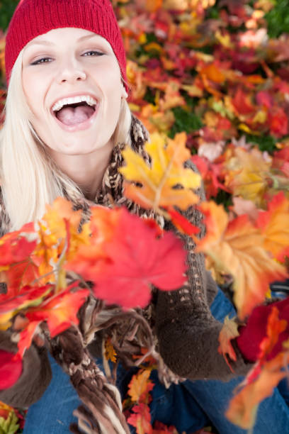 istock Laughing woman throwing autumn leaves 1034086166