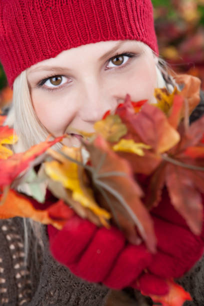 istock Smiling woman holding autumn leaves 1034086472
