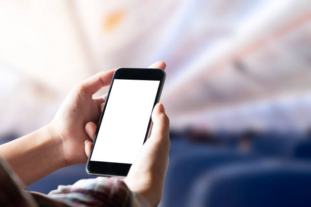 istock Airplane passenger using smart phone on plane. Businessman touching blank screen mobile phone at airplane. for graphics display montage. 1034105456