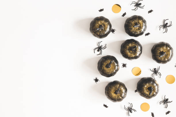 istock Halloween decorations, black pumpkins on white background. Halloween concept. Flat lay, top view, copy space 1034114048