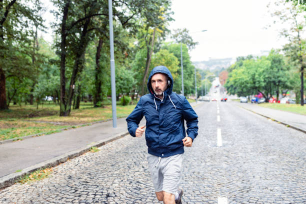 istock Man Jogging on a Rainy Day in the Park 1034144050