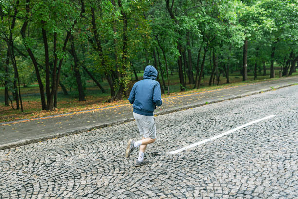 istock Man Jogging on a Rainy Day in the Park 1034144072