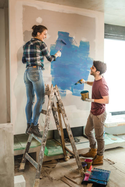 istock Young happy couple having fun while communicating and renovating their apartment. 1034144178