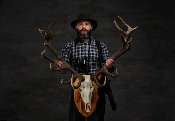 istock Bearded hunter in a fleece shirt and hat holds his trophy. 1034170836