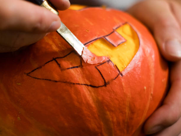 istock carving a Halloween pumpkin with a knife 1034171888