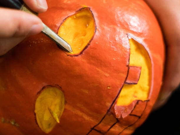 istock carving a Halloween pumpkin with a knife 1034171894