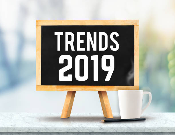 istock Trends 2019 on blackboard with easel on marble table with sun and blur green tree bokeh background.business vision concept. 1034181368