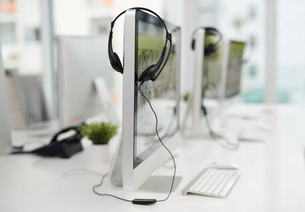 Closeup shot of a headset hanging on a computer screen in an office