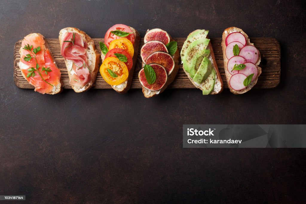 Brushetta or traditional spanish tapas Brushetta or traditional spanish tapas. Appetizers italian antipasti snacks set on wooden board. Top view and flat lay with space for your text Salmon - Seafood Stock Photo