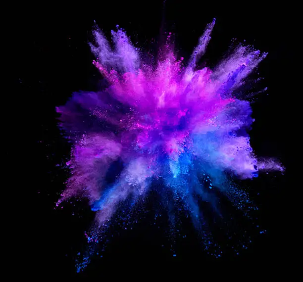 Photo of Explosion of coloured powder isolated on black background.