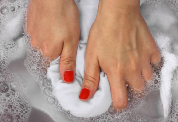 istock Female hands washing white clothes in basin 1034191194