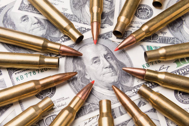 konzept von scharfer munition richtet sich an ein portrait benjamin franklin auf einer hundert-dollar-rechnung. krieg und gefahr - currency crime gun conflict stock-fotos und bilder