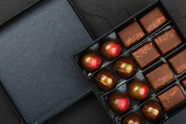 set of luxury handmade bonbons in box on black background - craft chocolate candy black box imagens e fotografias de stock