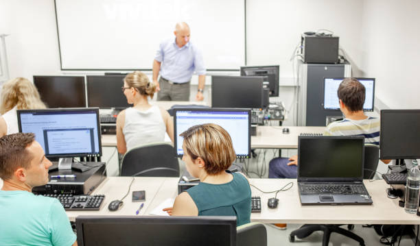 istock Professor and Adult Students Having Class in Computer Classroom 1034212422