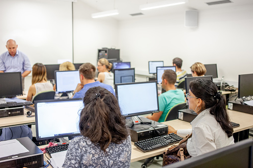 Adult Students Using Computers in Computer Lab in University.