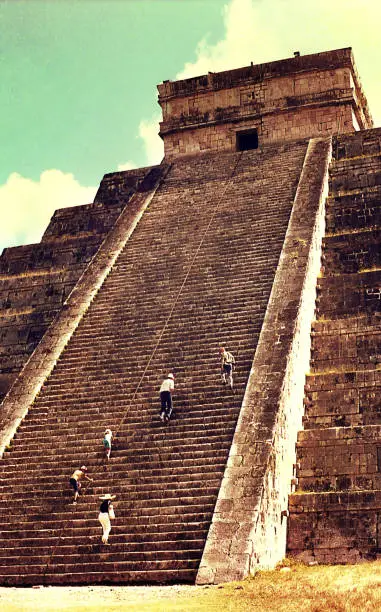 Vintage image of people climbing the Castillo pyramid in Chichen Itza, Mexico.