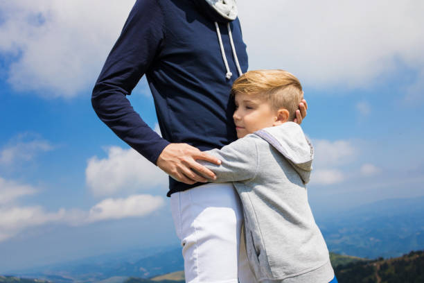 istock Sad little boy embracing his father against the sky. 1034217264