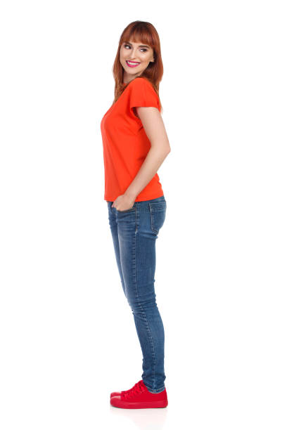 istock Young Woman Is Standing, Smiling And Looking Over Shoulder. Side View. 1034221404